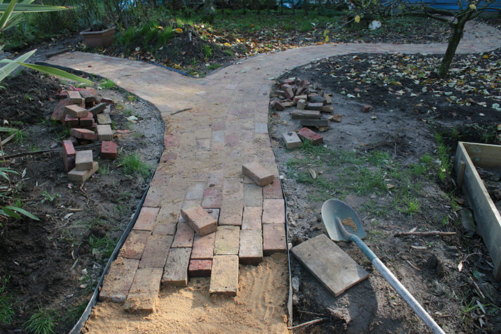 Landscape of garden path brick design project building constructing winding two fork lanes antique recycled reclaimed house bricks, cut in grass ground hard core base, edging & sand laid